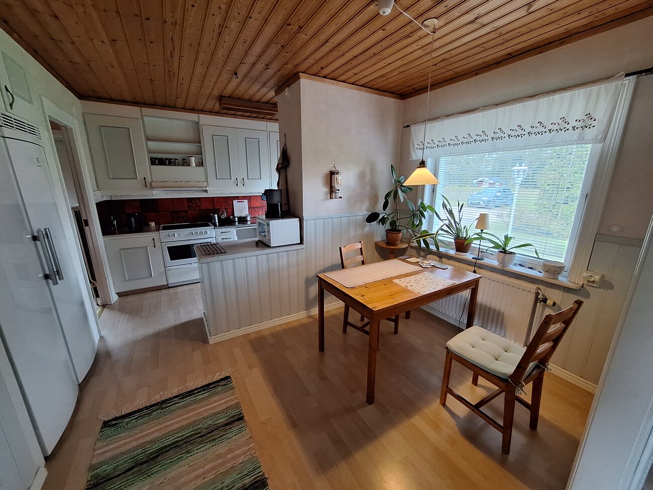 Inside a Swedish house, a kitchen with a wooden ceiling