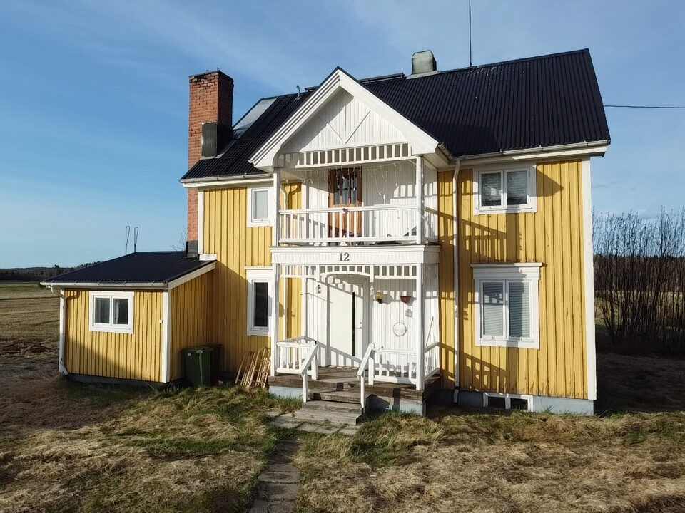 Gelbes Holzhaus mit weißer Veranda in Schweden