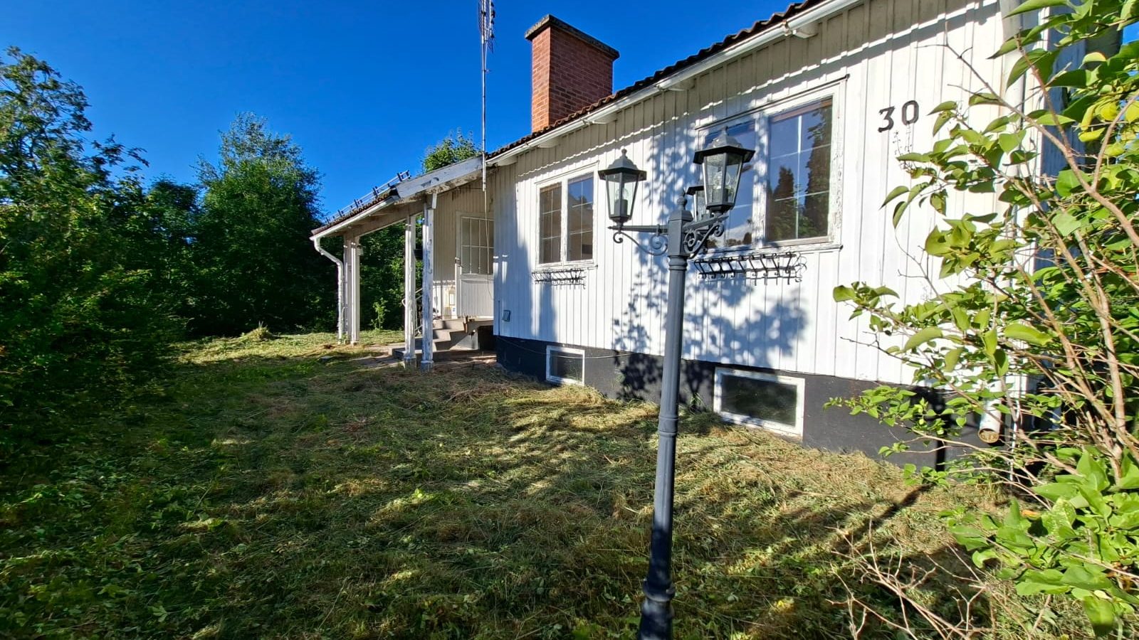 Weißes Holzhaus in Hagfors mit Garten und Laterne